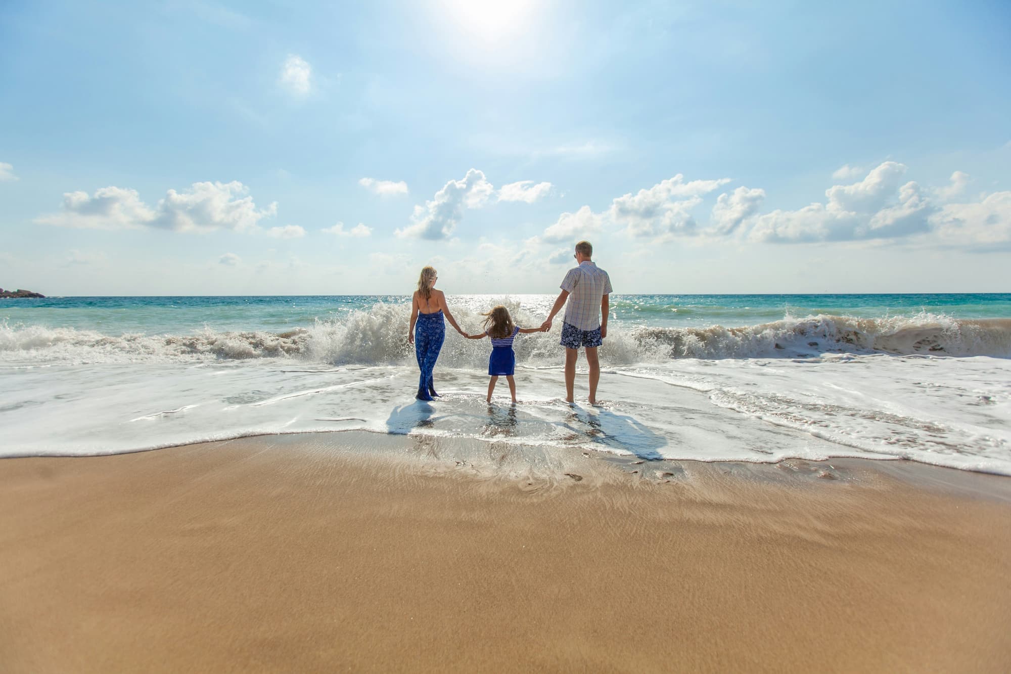 A family walking into the surf