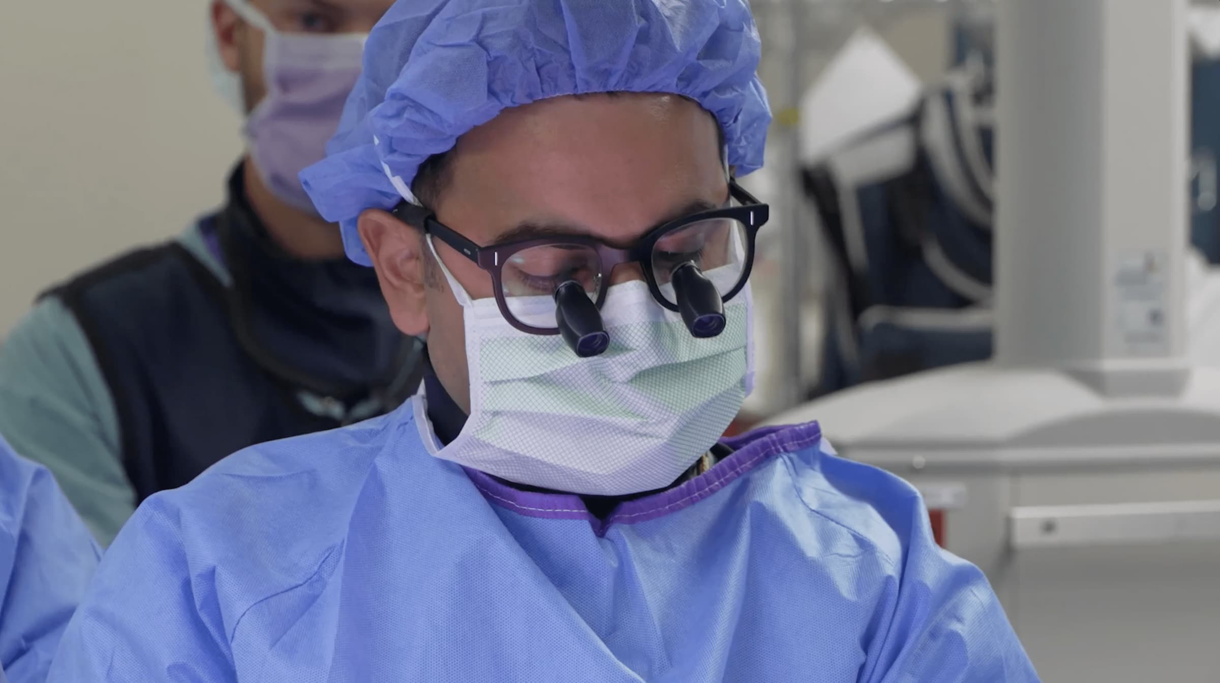 Dr. Sohaib Hashmi operating, wearing surgical loupes